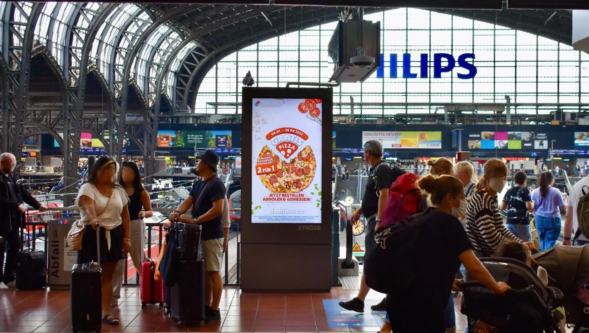 Domino's Kampagnenmotiv auf einem digitalen Screen im Bahnhofsumfeld